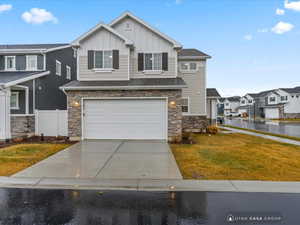 View of front of property featuring a front yard and a garage