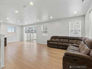 Living room with light wood-type flooring and a textured ceiling