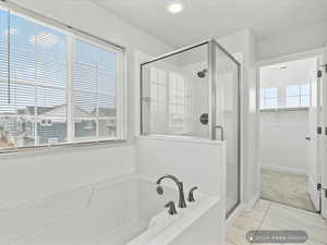 Bathroom with tile patterned floors, a wealth of natural light, and plus walk in shower