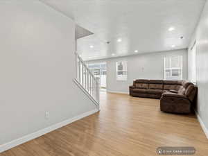 Living room featuring light hardwood / wood-style floors and a textured ceiling