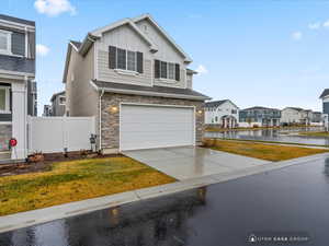 View of front of house featuring a front yard, a water view, and a garage