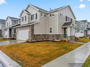 View of front of house featuring a garage and a front lawn