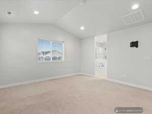 Carpeted empty room with lofted ceiling