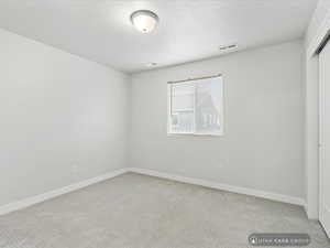 Unfurnished bedroom with light carpet and a closet