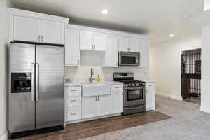 Kitchen with white cabinets, stainless steel appliances, and sink