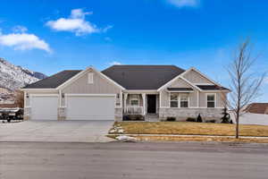 Craftsman-style house with a mountain view, a front lawn, a porch, and a garage