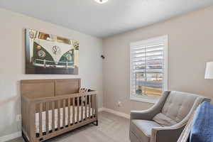 Bedroom featuring a crib and carpet