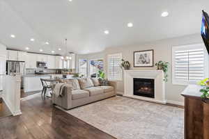 Living room with an inviting chandelier, light hardwood / wood-style flooring, and a wealth of natural light