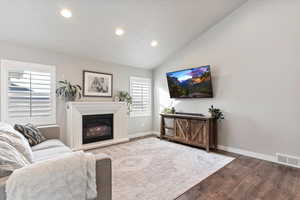 Living room with hardwood / wood-style floors and vaulted ceiling