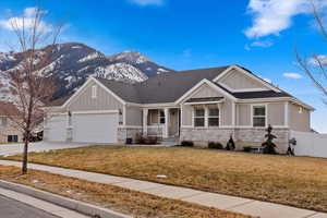 Craftsman-style home with a mountain view, a front lawn, a porch, and a garage