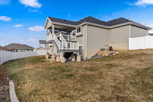 Back of house with a yard and a deck