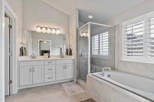 Bathroom featuring tile patterned floors, vanity, and independent shower and bath