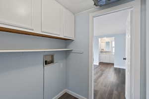 Laundry area featuring cabinets, hookup for a washing machine, and dark hardwood / wood-style floors