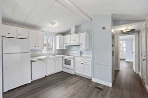 Kitchen with dark hardwood / wood-style flooring, white cabinets, and white appliances