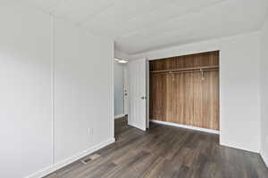 Bedroom featuring a closet and dark wood-type flooring