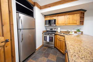 Kitchen featuring sink, ornamental molding, and appliances with stainless steel finishes