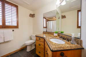 Bathroom with a shower with shower curtain, vanity, and toilet