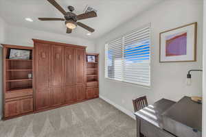 Unfurnished office featuring light carpet and ceiling fan