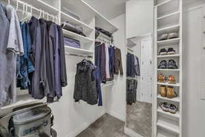 Walk in closet with carpet floors