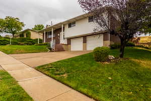 View of front of property featuring a front lawn and a garage