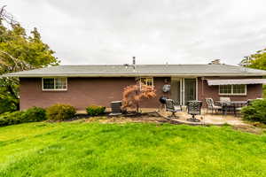 Back of property with a patio area, a yard, and central AC