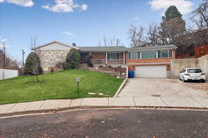 View of front of house with a garage and a front yard