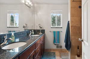 Bathroom featuring tile patterned flooring, vanity, and a healthy amount of sunlight