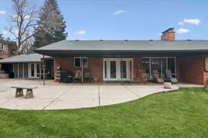 Rear view of property featuring a yard and a patio