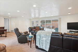 Living room featuring a textured ceiling and carpet floors