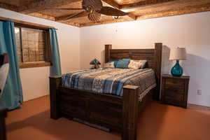 Bedroom featuring beam ceiling, ceiling fan, and wooden ceiling