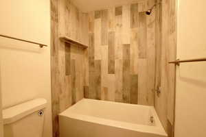 Bathroom with toilet and tiled shower / bath