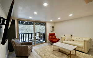 Living room with a wall mounted AC and light hardwood / wood-style flooring