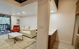 Living room with an AC wall unit and light hardwood / wood-style flooring