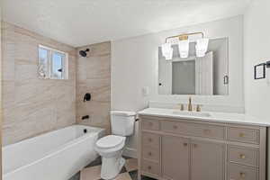 Full bathroom featuring vanity, toilet, and tiled shower / bath