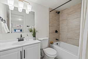 Ensuite primary bathroom featuring vanity, toilet, shower / bathtub combination.