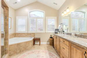 Bathroom with separate shower and tub, tile patterned flooring, vanity, and lofted ceiling