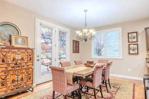 Dining space with light hardwood / wood-style floors and a notable chandelier