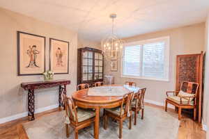 Dining space with hardwood / wood-style floors and an inviting chandelier