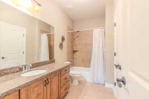 Full bathroom featuring tile patterned floors, vanity, toilet, and shower / bath combo