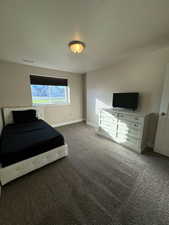 Unfurnished bedroom with dark carpet