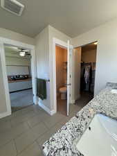 Bathroom featuring ceiling fan, tile patterned flooring, vanity, and toilet