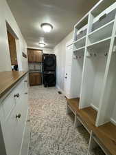 Mudroom with stacked washing maching and dryer and sink