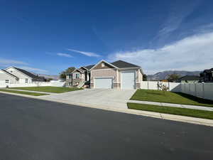 View of front facade featuring a mountain view, a garage, and a front yard