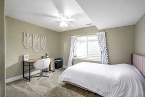 Carpeted bedroom featuring ceiling fan