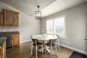 Dining space with a textured ceiling, dark hardwood / wood-style flooring, a chandelier, and vaulted ceiling