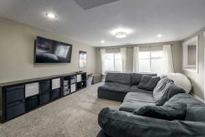 Carpeted living room with a textured ceiling