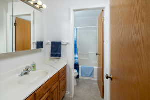 Full bathroom with shower / bath combo with shower curtain, vanity, and toilet