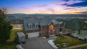 View of front of home with a mountain view, a garage, and a lawn