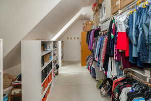 Walk in closet with lofted ceiling. Over top of garage