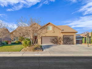 View of front of home featuring a front lawn and a garage